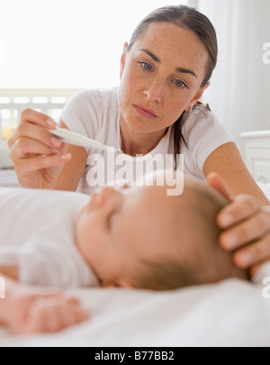 Besorgte Mutter Baby Sohn Temperatur prüfen Stockfoto