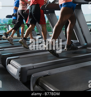 Männer und Frauen laufen auf Laufbändern Stockfoto