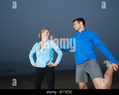 Paar am Strand dehnen Stockfoto