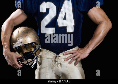 Football-Spieler trägt Uniform und Helm hält Stockfoto