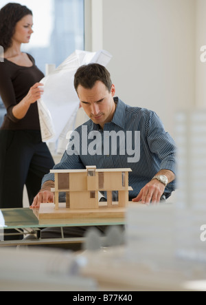 Architekten arbeiten Blaupausen und Gebäudemodell Stockfoto