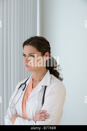 Ärztin aus Fenster schaute sinnend Stockfoto