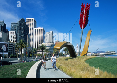 Paar Fahrrad vorbei an Amors Span Skulptur auf dem Embarcadero, San Francisco, Kalifornien Stockfoto