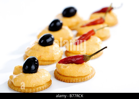 Cracker mit Paprika-Käse-Sahne, garniert mit roten Peperoni Stockfoto