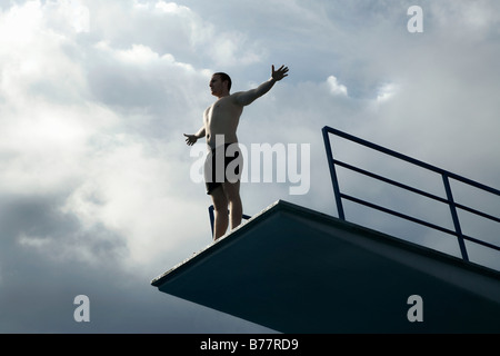 Junger Mann stehend auf einem Sprungturm Stockfoto