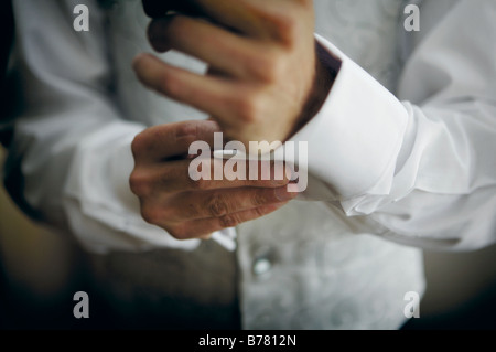 Bräutigam seine Manschettenknöpfe vor Hochzeitstag Befestigung Stockfoto