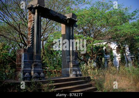 Adil Shah Palast Tor Ruine isolierte Tor Mauerwerk Schritte zugewachsen Haus mit Fensterläden hinter OLD GOA GOA Indien Stockfoto