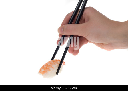 eine Hand mit Stäbchen, hob ein Stück Sushi isoliert auf weiss Stockfoto