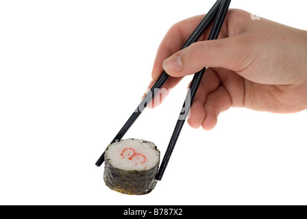 eine Hand mit Stäbchen Abholung eine Sushi-Rolle, isoliert auf weiss Stockfoto