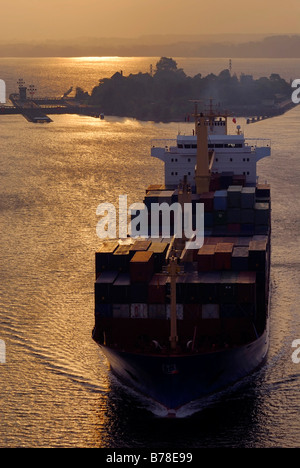 Container schiff Verlassen der Holtenauer Schleuse bei Sonnenaufgang, Kiel, Schleswig-Holstein, Deutschland, Europa Stockfoto