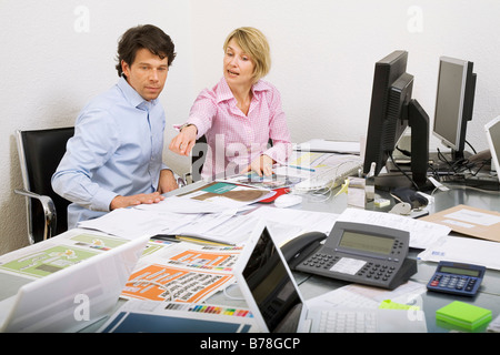 Mitarbeiter einer Werbeagentur, die Diskussion über eine Ad-Broschüre und Baupläne von einer Anzeige Kampagne, Zürich, Schweiz, Europa Stockfoto