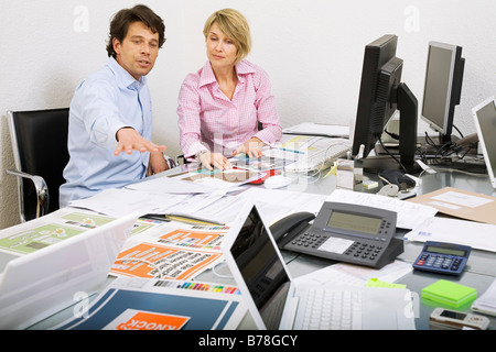 Mitarbeiter einer Werbeagentur, die Diskussion über eine Ad-Broschüre und Baupläne von einer Anzeige Kampagne, Zürich, Schweiz, Europa Stockfoto