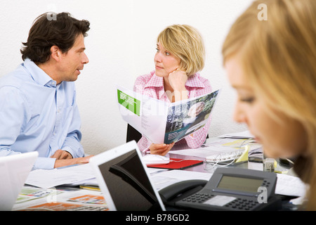 Mitarbeiter einer Werbeagentur, die Diskussion über eine Ad-Broschüre und Baupläne von einer Anzeige Kampagne, Zürich, Schweiz, Europa Stockfoto