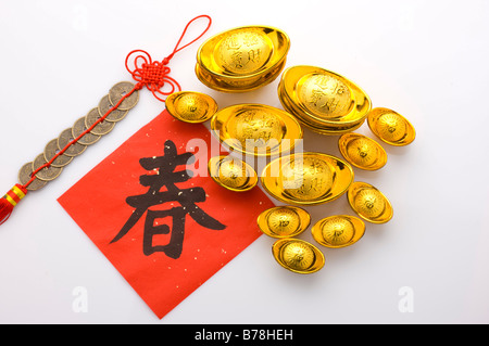 Nahaufnahme von Goldbarren, Chinese New Year Banner und eine traditionelle Verzierung gemacht Kupfermünzen Stockfoto