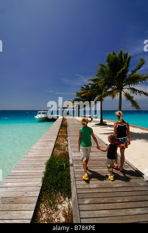 Frau und zwei Kindern zu Fuß entlang der Mole, Laguna Resort, Malediven, Indischer Ozean Stockfoto