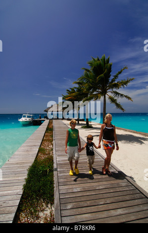 Frau und zwei Kindern zu Fuß entlang der Mole, Laguna Resort, Malediven, Indischer Ozean Stockfoto