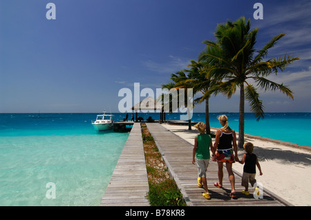 Frau und zwei Kindern zu Fuß entlang der Mole, Laguna Resort, Malediven, Indischer Ozean Stockfoto