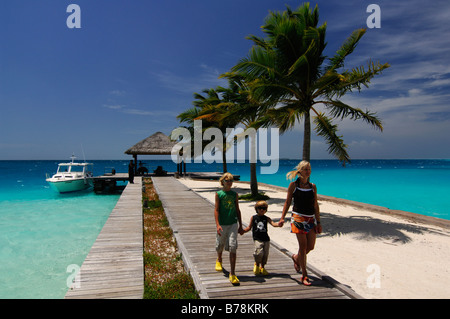 Frau und zwei Kindern zu Fuß entlang der Mole, Laguna Resort, Malediven, Indischer Ozean Stockfoto