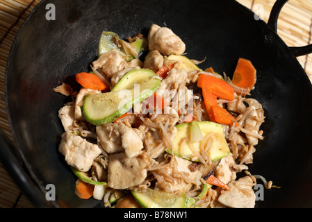 Chinese Chicken Stir-Fry in einem Wok, erschossen in einem Winkel. Stockfoto