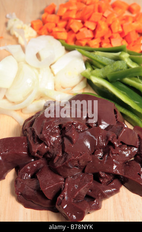 Gehackte Lamm Leber, Zwiebeln, Karotten und Paprika auf einem Holzbrett - Zutaten für ein leckeres Leber Eintopf oder Stroganoff. Stockfoto