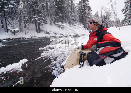 Ein Mann Schneeschuhwanderung entlang des Truckee River während es in Truckee in Kalifornien schneit Stockfoto