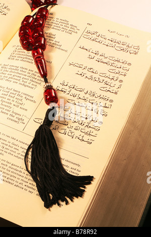 Seite aus dem Heiligen Koran in Arabisch und Englisch, mit Gebetskette. Stockfoto