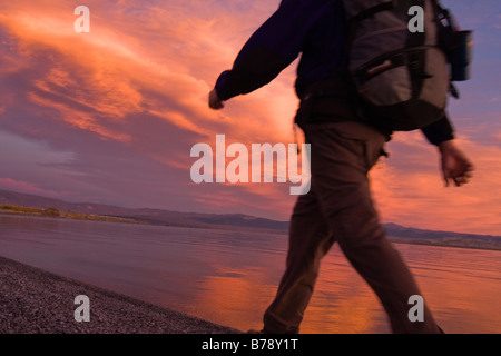 Ein Mann, Wandern entlang der Ufer des Mono Lake mit reflektierenden Wasser und Wolken in Kalifornien Stockfoto