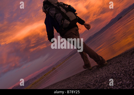 Ein Mann, Wandern entlang der Ufer des Mono Lake mit reflektierenden Wasser und Wolken in Kalifornien Stockfoto