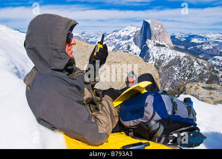 Backcountry Skifahrer mit Radio und Half Dome vom Glacier Point Yosemite Nationalpark, Kalifornien Stockfoto