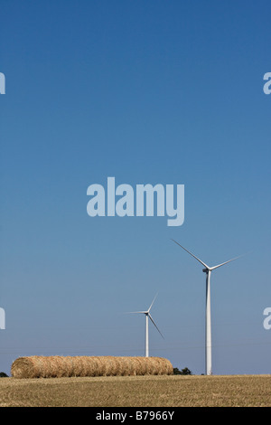 Wind-Turbinen Stand als nächstes auf Heuballen in Kansas. Stockfoto
