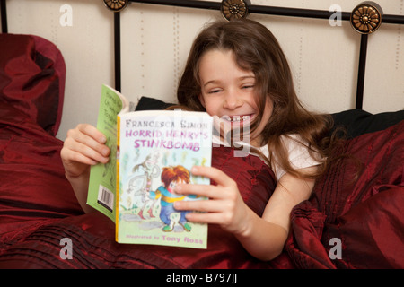 junges Mädchen ein Buch im Bett lesen Stockfoto