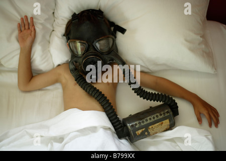 Sechs Jahre alte junge liegt im Bett mit Gasmaske Stockfoto