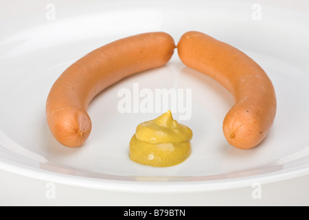 ein paar Würstchen auf einem weißen Teller Stockfoto
