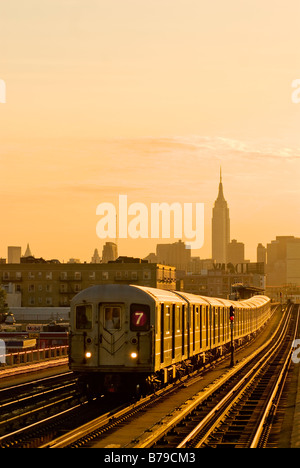 Die Zahl 7 erhöhten u-bahn in Long Island City, Queens, New York City, mit dem Empire State Building im Hintergrund. Stockfoto