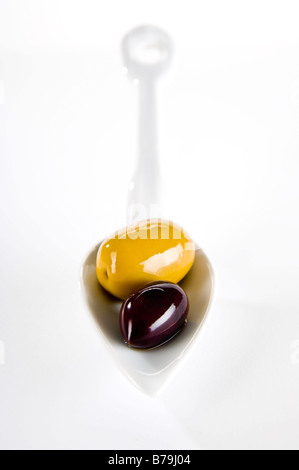 Keramik Löffel mit Oliven. Schuss mit geringen Schärfentiefe, in den Vordergrund und unscharfen Hintergrund scharf zu machen. Stockfoto