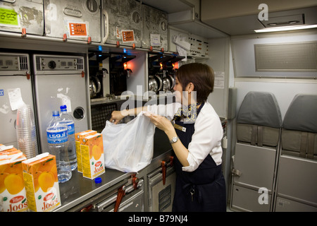 Mitglied der Kabinenbesatzung arbeiten / aufräumen in der Küche auf einem Gulf Air Airbus A330 Flugzeug während des Fluges (Bahrain / London). (45) Stockfoto