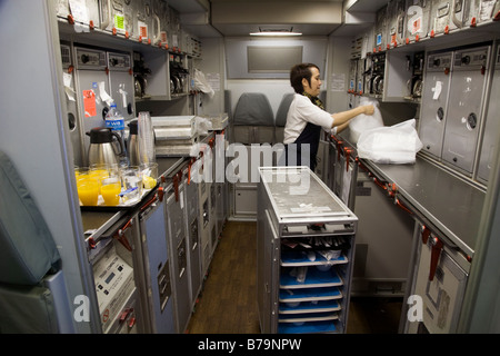 Mitglied der Kabinenbesatzung arbeiten / aufräumen in der Küche auf einem Gulf Air Airbus A330 Flugzeug während des Fluges nach Bahrain aus London. 45 Stockfoto