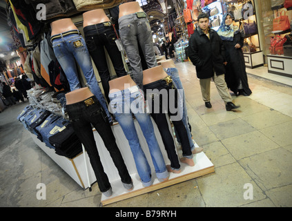 Eine lokale türkische paar gehen vorbei an einem Stall zu verkaufen Jeans auf dem Basar (Kapali Carsi) in Istanbul, Türkei. Stockfoto