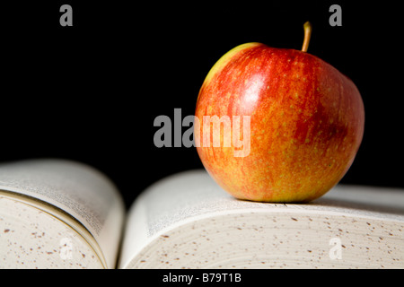 Apfel auf Buch Stockfoto