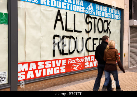 Paar vorbei ein Zeichen für alle Lager reduziert Einsparungen im Schaufenster England 2009 Stockfoto