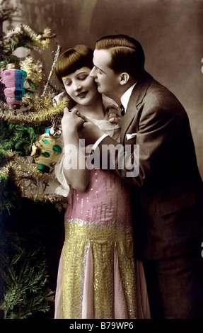 Zärtliche Umarmung unter dem Weihnachtsbaum und küssen Stockfoto