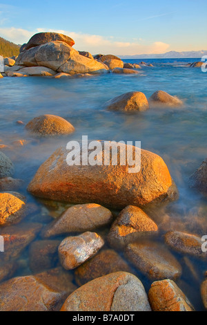 HDR-Tonemapped-Felsen und bewegtes Wasser bei Sonnenuntergang am Ostufer des Lake Tahoe in Nevada Stockfoto