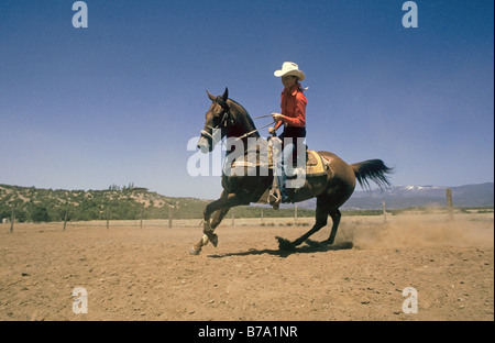 Eine junge Cowgirl trainiert ihr Viertelpferd für Faßlaufen für eine bevorstehende Rodeo an der New Mexico State fair, Santa Fe, New Mexico. Stockfoto