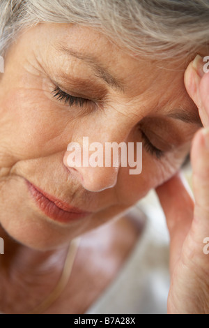 Ältere Frau mit Kopf in den Händen, die Müde Stockfoto