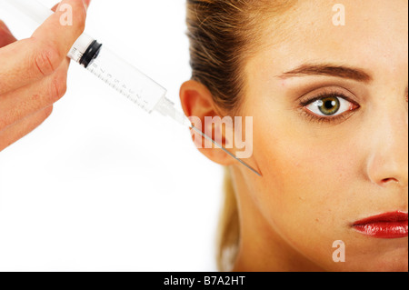 Junge Frau mit einer Spritze gegen Falten Stockfoto