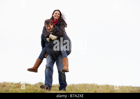 Mann seine Frau Piggy Back Ride Stockfoto