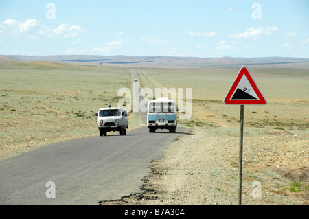 Russischen kleinen Bus und Bus auf gerader Straße mit Straße Abstieg unterzeichnen, breite Wiese plain, baumlose Steppe, Mongolei, Asien Stockfoto