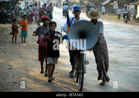 Junge Menschen drängen einen Lautsprecher auf einem Fahrrad durch die Straßen von Bago, Burma, Myanmar, Südostasien Stockfoto