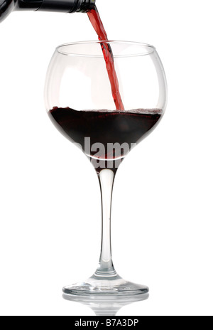 Rotwein aus der Flasche gegossen wird, ins Weinglas isoliert gegen weiß Stockfoto