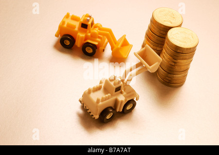 Miniatur-Traktoren und Münzen Stockfoto